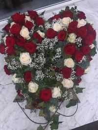 Stehendes Urmenherz mit roten und creme farbenen Rosen